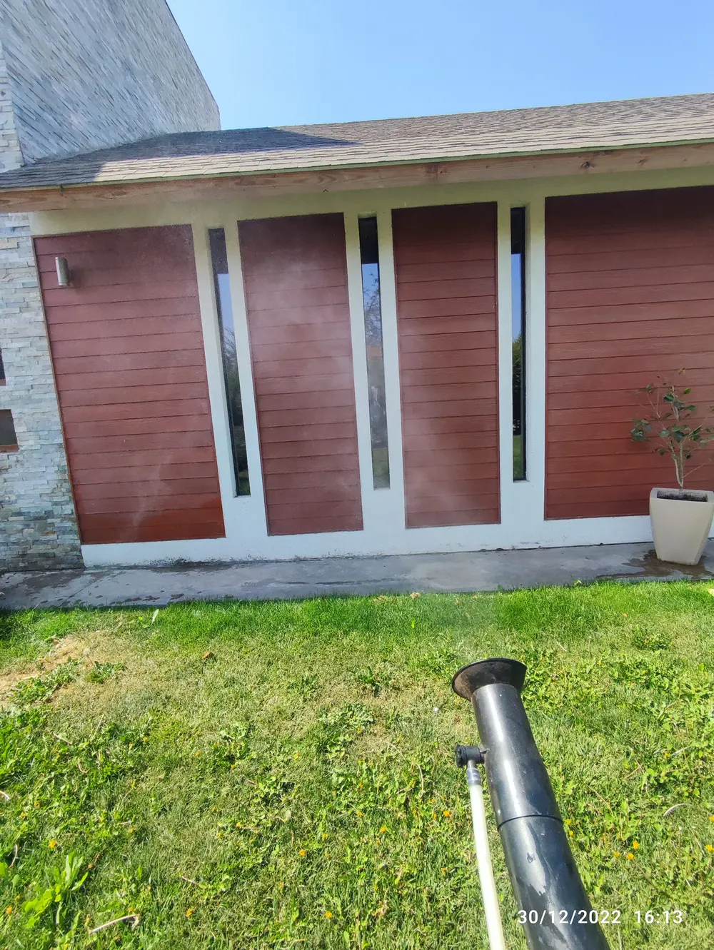 Técnico fumigando el jardín de una casa con cañón nebulizador